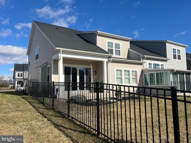 rear view of house featuring a lawn