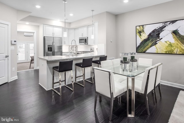 dining room featuring dark hardwood / wood-style flooring and an AC wall unit