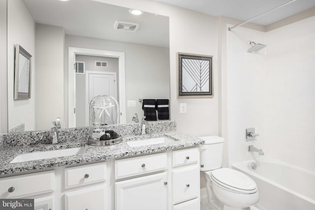 full bathroom with tiled shower / bath, vanity, and toilet