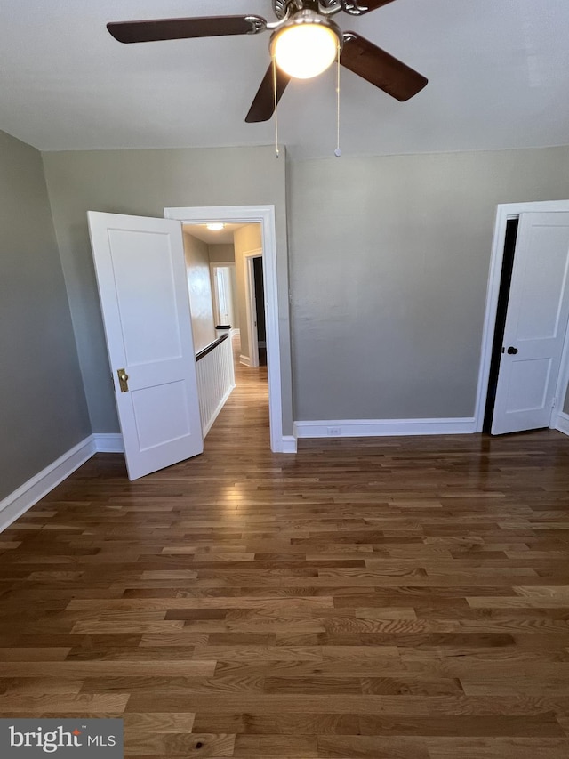 empty room featuring dark wood-type flooring and ceiling fan