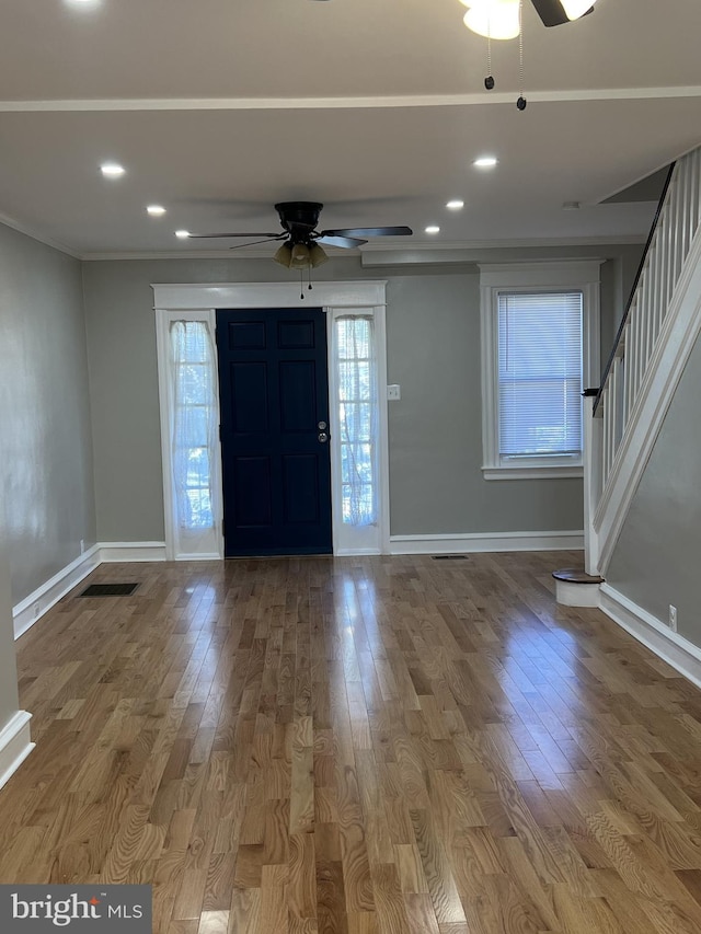 foyer featuring ceiling fan, crown molding, and light hardwood / wood-style floors