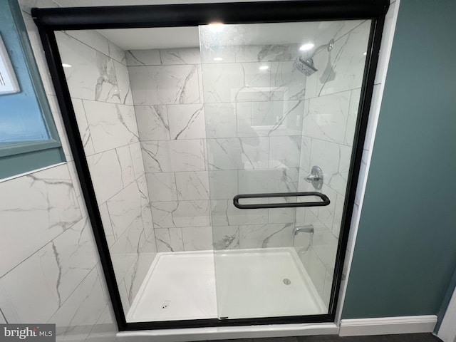 bathroom with a shower with door