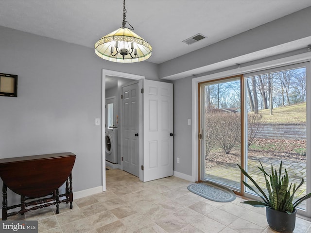 doorway to outside featuring an inviting chandelier