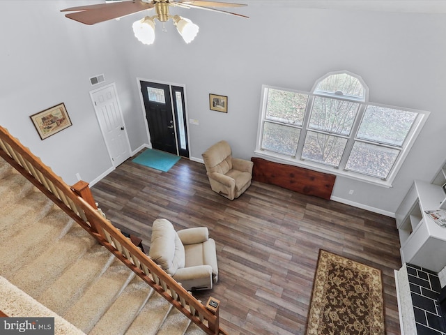 living room with a towering ceiling, ceiling fan, and hardwood / wood-style flooring