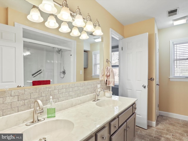 bathroom featuring vanity, decorative backsplash, and walk in shower