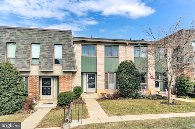 townhome / multi-family property featuring a front lawn