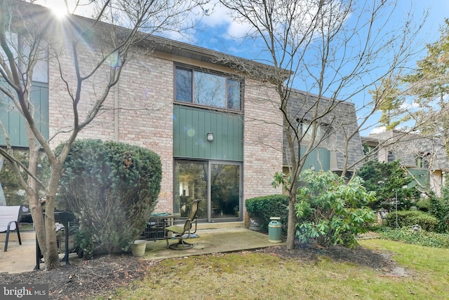 back of property with a yard and a patio area