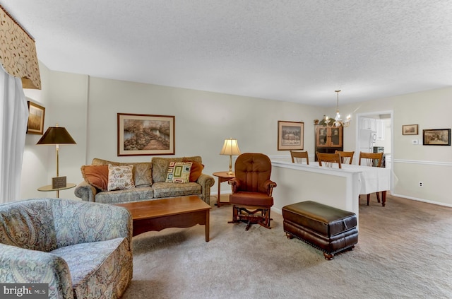 carpeted living room featuring an inviting chandelier and a textured ceiling