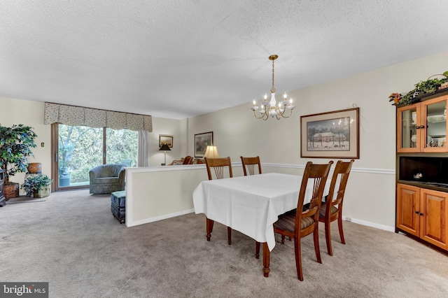 carpeted dining area with a chandelier and a textured ceiling