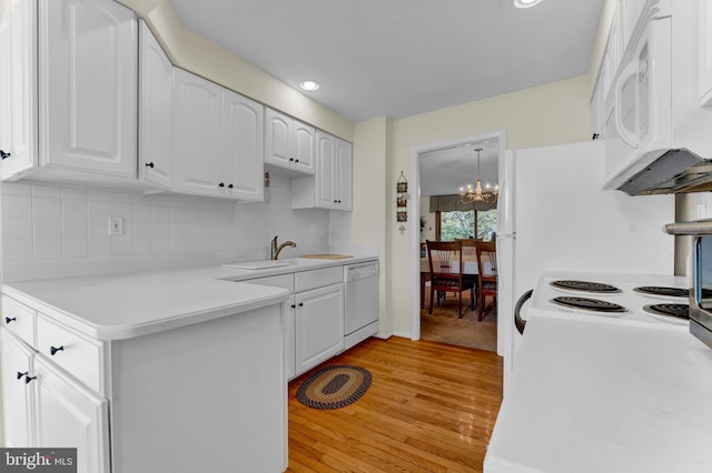 kitchen with sink, light hardwood / wood-style flooring, white appliances, decorative backsplash, and white cabinets