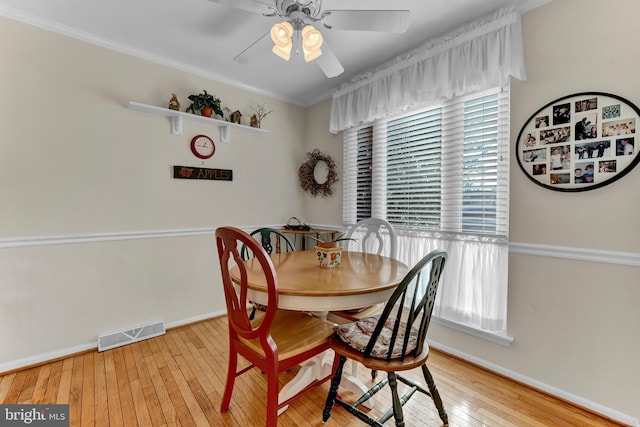 dining area with ornamental molding, ceiling fan, and light wood-type flooring