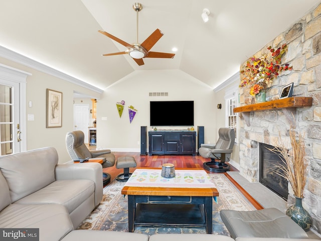 living room with ceiling fan, a fireplace, vaulted ceiling, and hardwood / wood-style floors