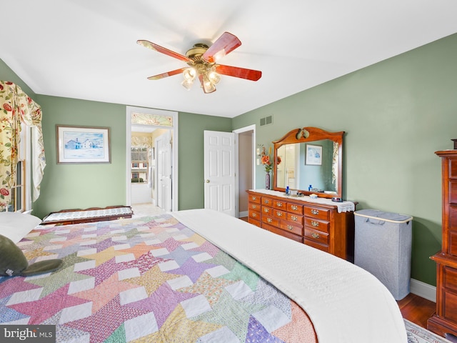 bedroom featuring hardwood / wood-style flooring, ceiling fan, and ensuite bath