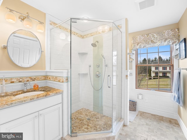 bathroom with vanity, tile walls, and walk in shower