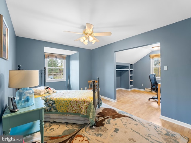 bedroom with ceiling fan, a spacious closet, and light wood-type flooring