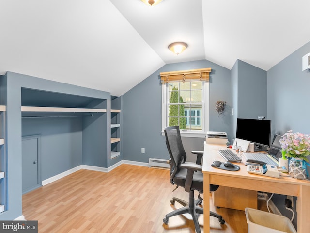 office space with baseboard heating, built in shelves, vaulted ceiling, and hardwood / wood-style flooring