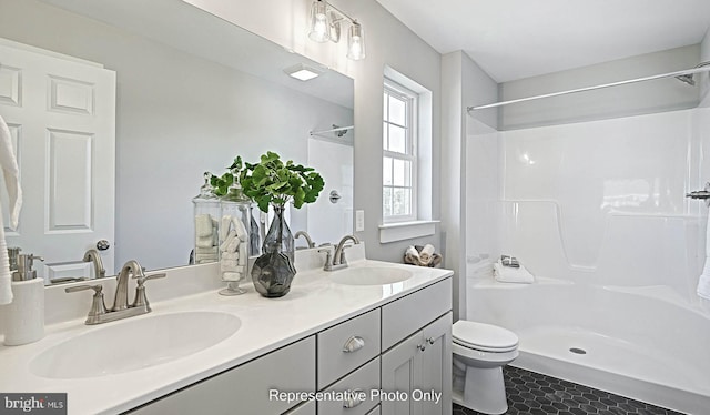 bathroom with tile patterned flooring, vanity, toilet, and walk in shower