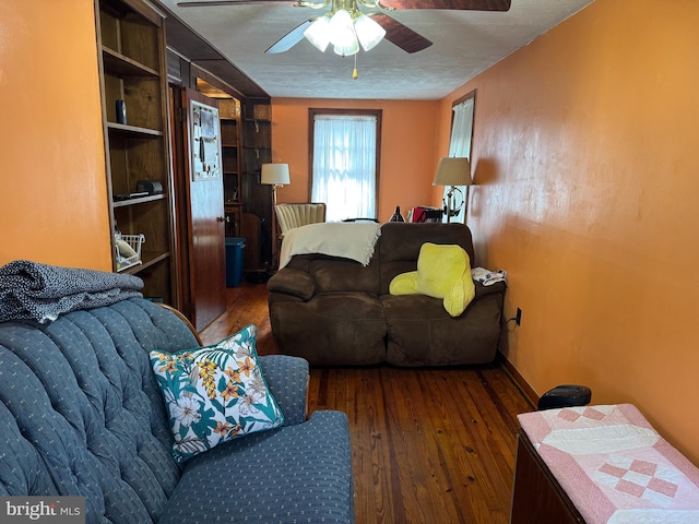 living room with ceiling fan, dark hardwood / wood-style floors, and a textured ceiling