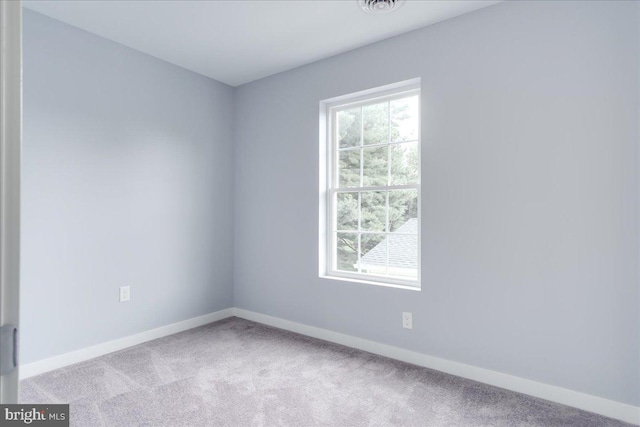 empty room with light colored carpet and a healthy amount of sunlight