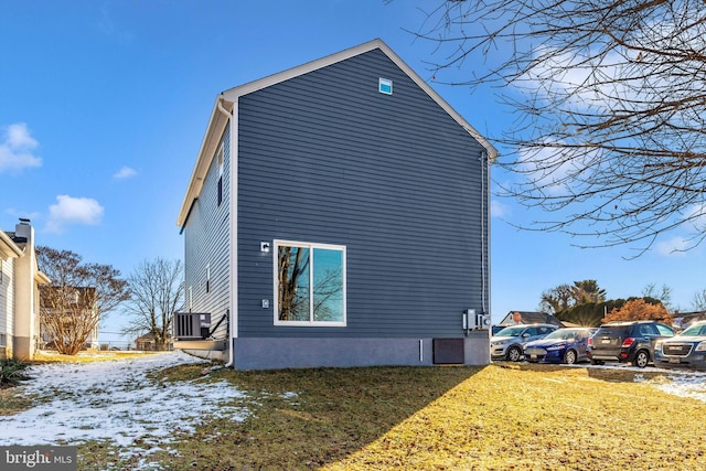 view of home's exterior with cooling unit and a yard