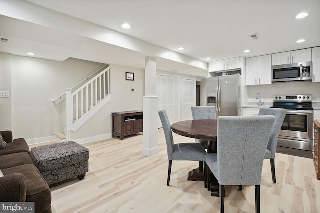 dining area with sink and light hardwood / wood-style floors