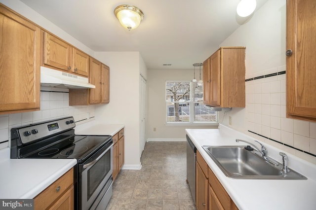 kitchen with appliances with stainless steel finishes, sink, pendant lighting, and decorative backsplash