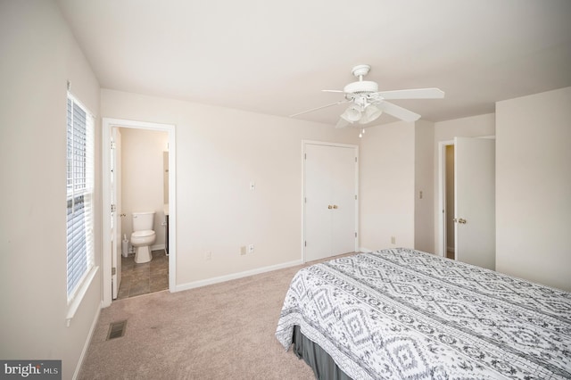 bedroom featuring light carpet, ensuite bath, and ceiling fan