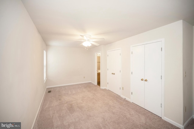 unfurnished bedroom featuring light carpet and ceiling fan