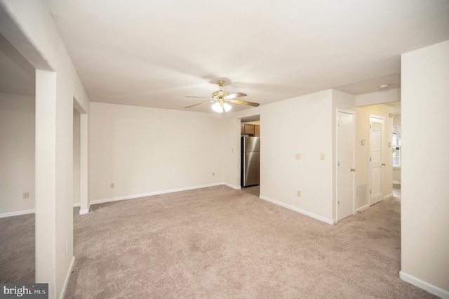 carpeted spare room featuring ceiling fan