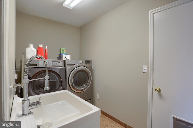 laundry area featuring laundry area, light tile patterned floors, baseboards, and washing machine and clothes dryer