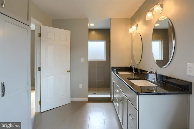 full bath featuring tile patterned floors, walk in shower, a sink, and double vanity