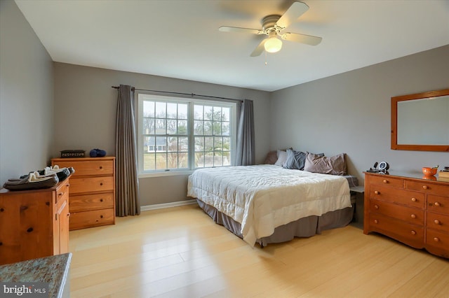 bedroom featuring light wood-style floors, baseboards, and a ceiling fan