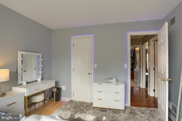 bedroom with light wood-type flooring and visible vents