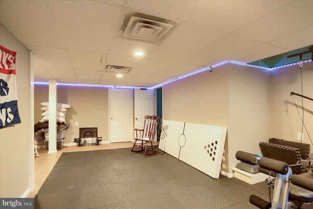 interior space with a paneled ceiling, visible vents, and baseboards