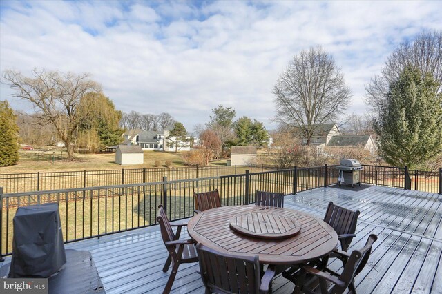 deck featuring outdoor dining area, a yard, area for grilling, a residential view, and a fenced backyard