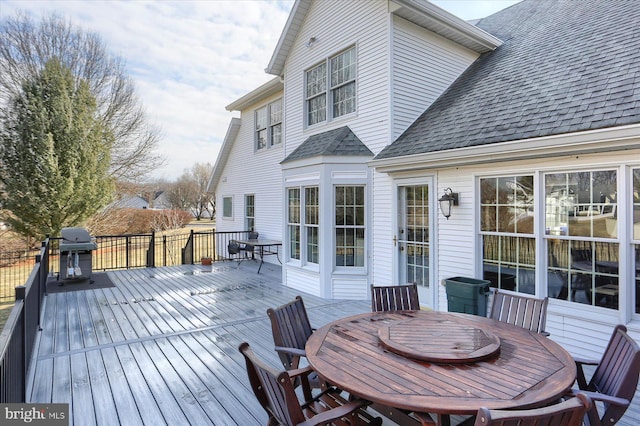 deck featuring outdoor dining space and a grill