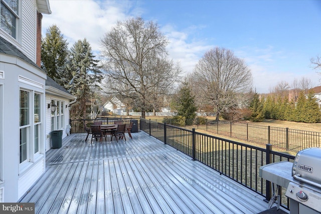 deck with a yard, outdoor dining space, a fenced backyard, and a grill