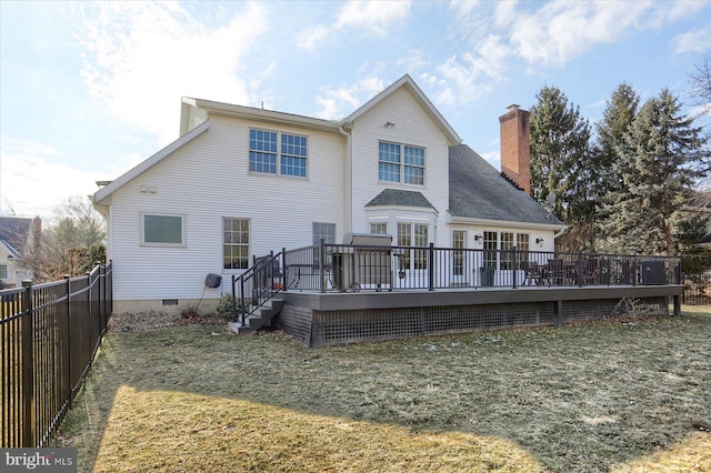 rear view of house with a fenced backyard, crawl space, a lawn, a wooden deck, and a chimney