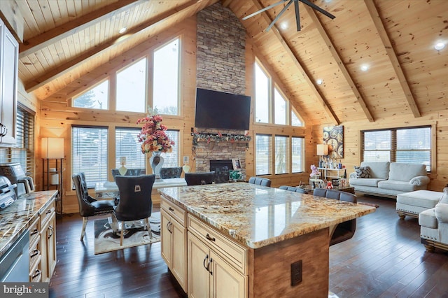 kitchen with wooden walls, dark wood-style flooring, a stone fireplace, wooden ceiling, and open floor plan