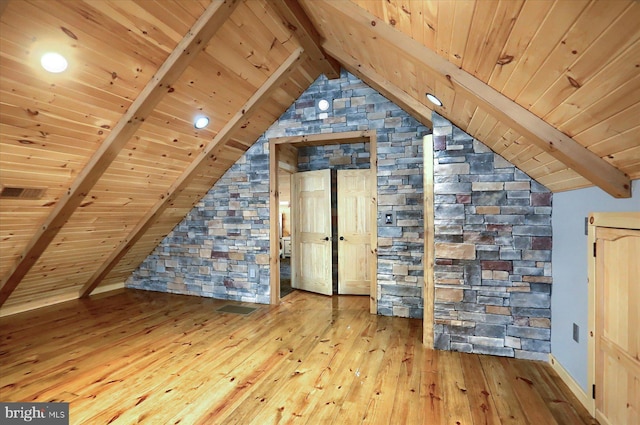 additional living space featuring lofted ceiling with beams, visible vents, hardwood / wood-style floors, and wooden ceiling