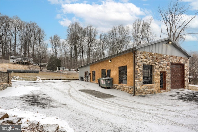 view of snowy exterior with stone siding