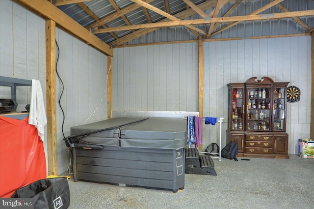 misc room featuring lofted ceiling and metal wall