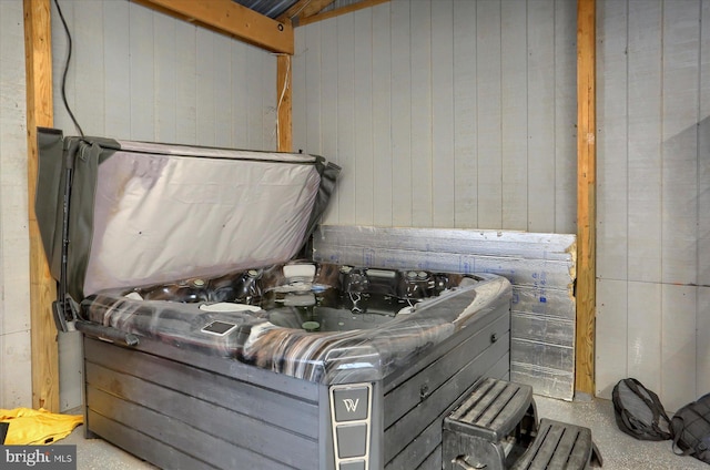 misc room featuring speckled floor, wood walls, and a hot tub