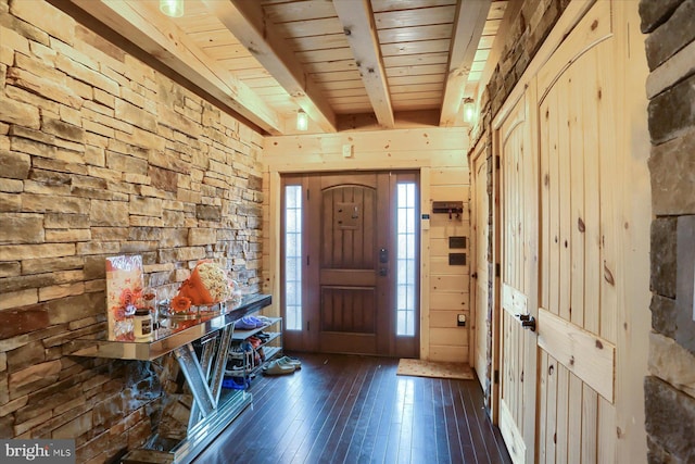 entrance foyer with dark wood-style floors, beamed ceiling, wooden ceiling, and wooden walls