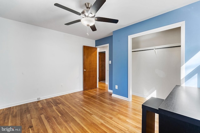 unfurnished bedroom with a ceiling fan, a closet, baseboards, and wood finished floors