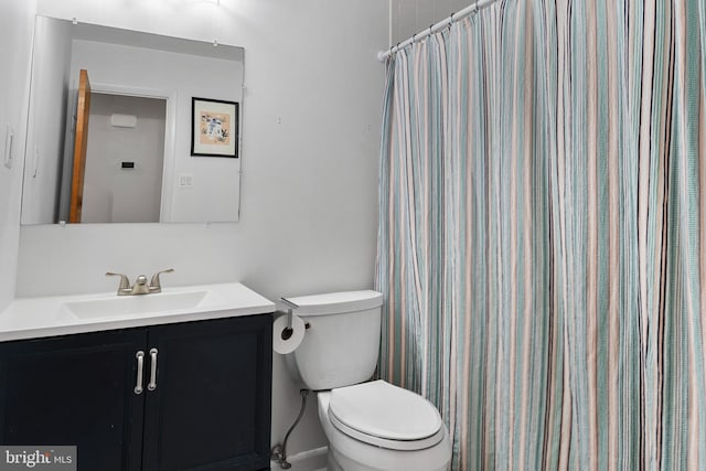 bathroom with toilet, curtained shower, and vanity