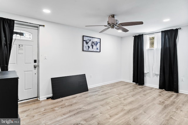 foyer entrance with ceiling fan, light wood-type flooring, plenty of natural light, and baseboards