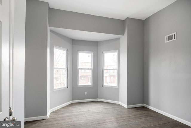 unfurnished room with hardwood / wood-style flooring