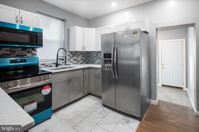 kitchen with white cabinetry, sink, gray cabinetry, decorative backsplash, and stainless steel appliances