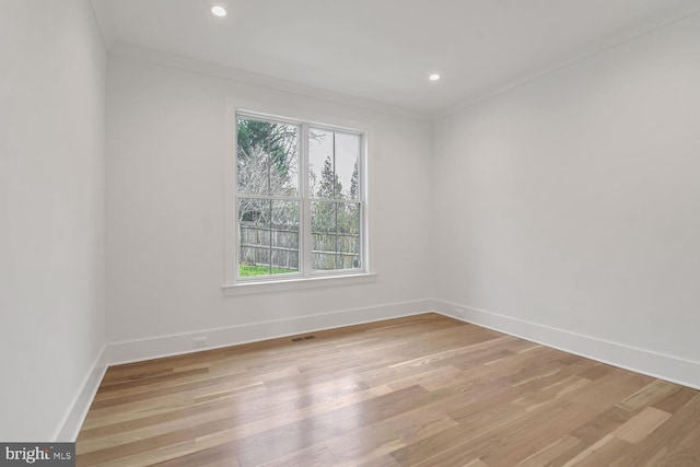 empty room featuring light hardwood / wood-style flooring and ornamental molding